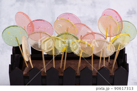 Close-up shot of a whole brownie decorated with glass lollypops. Close-up shot of a whole brownie decorated with glass lollypops. 90617313