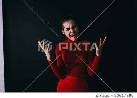 Angry female in red outfit in black room Angry female in red outfit in black room 90617890