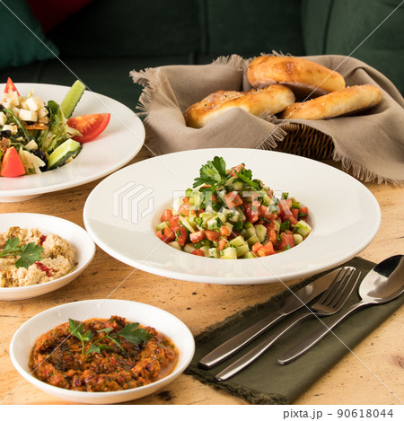 Close up shot of salads and appetizers near basket of breads Close up shot of salads and appetizers near basket of breads 90618044