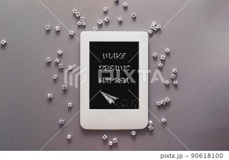 Slogan Make Dreams Happen on tablet on grey background Slogan Make Dreams Happen on tablet on grey background 90618100