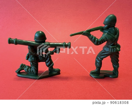銃を構える2人の兵士の人形形（赤背景）、戦争イメージ 90618308