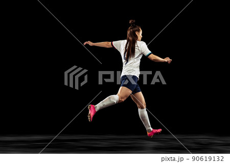 Back view of energetic soccer, football player running isolated on dark background. Sport, action, competitions, games and fitness concept Back view of energetic soccer, football player running isolated on dark background. Sport, action, competitions, games and fitness concept 90619132