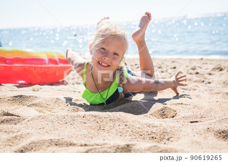 Portrait of little girl with inflatable rubber circle on beach 90619265