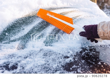 Cleaning the car from snow with a modern rubber brush Cleaning the car from snow with a modern rubber brush 90620278