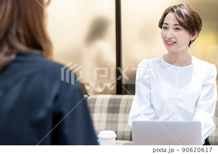 オフィスの休憩スペースで相談を受けるミドル女性 90620617