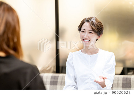 オフィスの休憩スペースで相談を受けるミドル女性 90620622