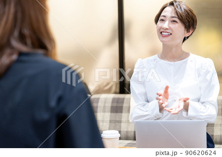 オフィスの休憩スペースで相談を受けるミドル女性 90620624