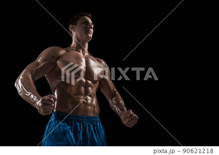 Muscular and fit young bodybuilder fitness male model posing over black background. Muscular and fit young bodybuilder fitness male model posing over black background. 90621218