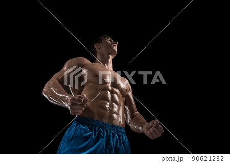 Muscular and fit young bodybuilder fitness male model posing over black background. Muscular and fit young bodybuilder fitness male model posing over black background. 90621232