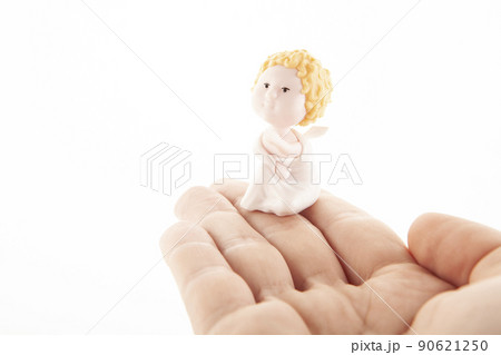 image of miniature angel figure hand white background  90621250