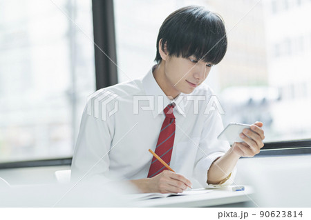 教室でスマートフォンを見る男性高校生 90623814