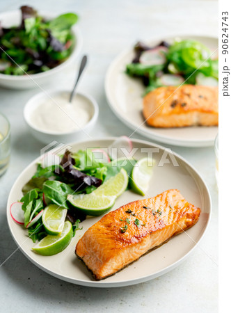 Grilled salmon fillet and fresh vegetable salad. Mediterranean diet.  90624743
