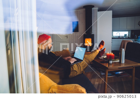 Man with laptop in house room with fireplace Man with laptop in house room with fireplace 90625013