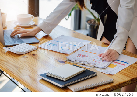 Young economists or accountants or financiers and investors are reviewing budget documents and using computers to study impact and risk assessments on corporate investment management 90627959