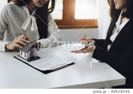 Guarantee, mortgage, contract, contract, signed, real estate agent or bank officer holding a calculator, submits a bid with a customer to buy a home before signing to make a deal. 90628046