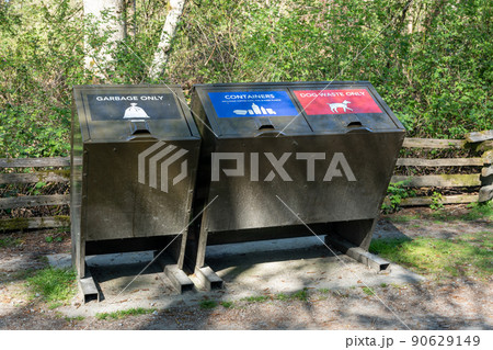 Garbage bin for garbage only and containers and dog waste only. Trash container in public park. 90629149