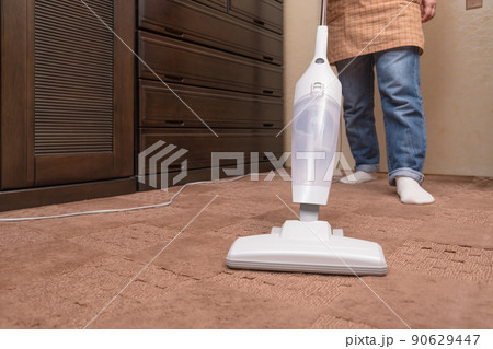 【ハンディクリーナーで絨毯を掃除するミドル主婦】 90629447