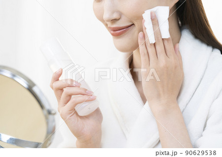 鏡を見てスキンケアをする女性の手元 鏡を見てスキンケアをする女性の手元 90629538