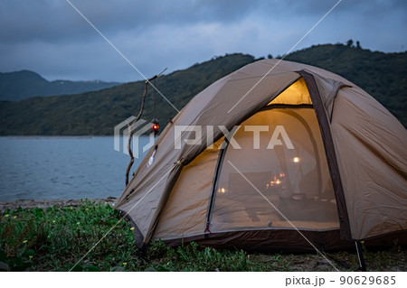 野営キャンプ ソロテント 無骨キャンプ 後ろ姿 海コピースペース ランプ 灯り 夕暮れ 夜キャンプ 90629685