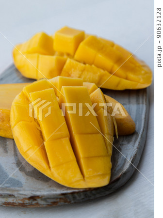 Fresh ripe yellow mango fruit (Barracuda mango) on ceramic plate. 90632128