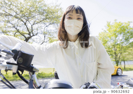 バイク女子イメージ　マスク姿でバイクにまたがる若い女性 90632692