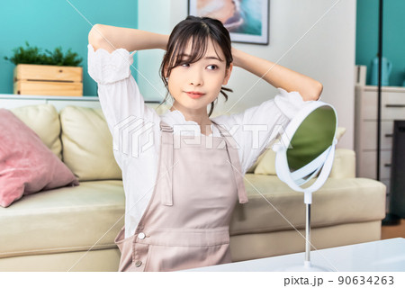 髪をまとめる若い女性 90634263
