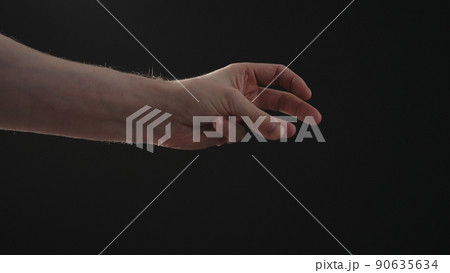 man hand playing with sun light on a black background man hand playing with sun light on a black background 90635634