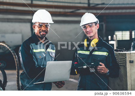 Two factory workers using adept machine equipment in a workshop 90636594