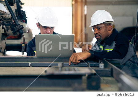 Factory workers working with adept robotic arm in a workshop 90636612