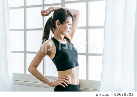 ストレッチ・柔軟体操するヨガウェアの中高年女性（横顔） 90638602