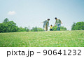 緑の丘で遊びまわる家族 90641232