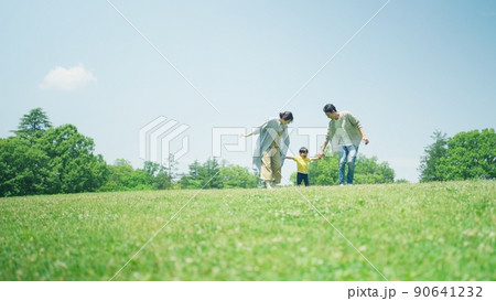 緑の丘で遊びまわる家族 90641232