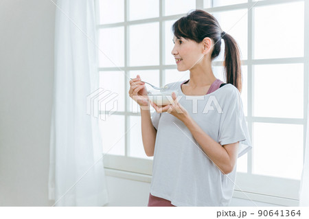ヨーグルトを食べて菌活する中高年女性（笑顔） 90641364