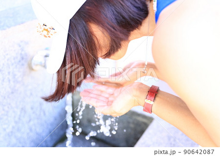 公園の水道で顔を洗う女性 公園の水道で顔を洗う女性 90642087
