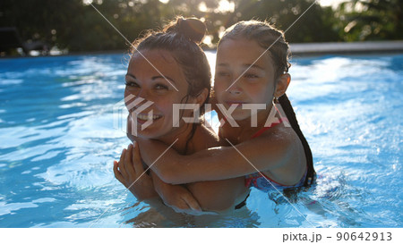 Happy caucasian mother and her cute daughter swim in the pool on sunny tropical island. 4k Happy caucasian mother and her cute daughter swim in the pool on sunny tropical island. 4k 90642913