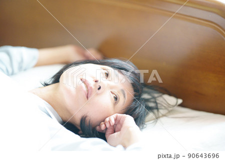朝のまどろみ 爽やかな目覚めの中年女性 朝のまどろみ 爽やかな目覚めの中年女性 90643696