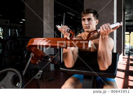 Tense muscles of hands under load. Man doing exercise for biceps in the gym. Tense muscles of hands under load. Man doing exercise for biceps in the gym. 90643951