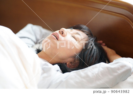 口を開けて眠る中年女性　鼾をかく中年女性 90643982