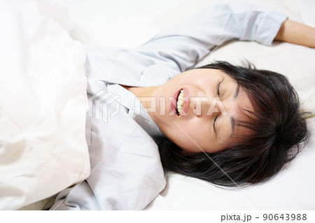 口を開けて眠る中年女性　鼾をかく中年女性 90643988