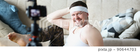 Middle aged man record video classes of doing sports on videocamera 90644703