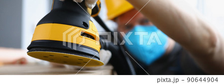 Man carpenter work with professional sander machine on flat project 90644904