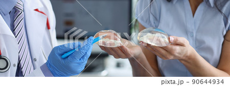 Professional doctor explain difference between breast implants to client 90644934