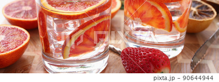 Orange punch with green mint served with strawberry on wooden table Orange punch with green mint served with strawberry on wooden table 90644944