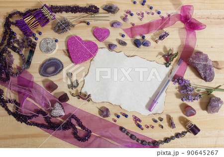 Purple and Pink Jewelry and Flowers with Silver Coin Vintage Paper and Pen in center of Wooden Table Purple and Pink Jewelry and Flowers with Silver Coin Vintage Paper and Pen in center of Wooden Table 90645267