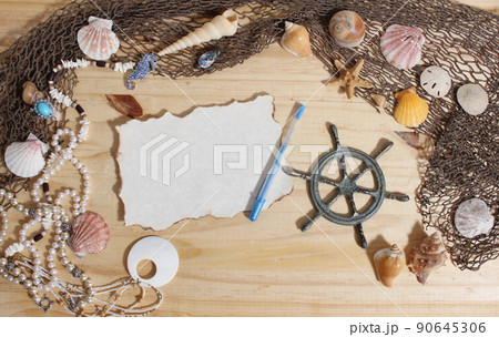 Blank Paper With Burned Edges on Wooden Background With Sea Shells and Fishing Net. Nautical and Coastal Theme Blank Paper With Burned Edges on Wooden Background With Sea Shells and Fishing Net. Nautical and Coastal Theme 90645306