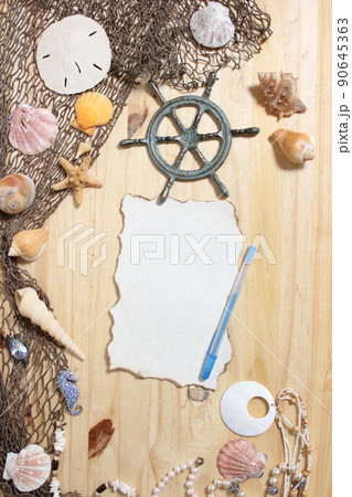 Blank Paper With Burned Edges on Wooden Background With Sea Shells and Fishing Net. Nautical and Coastal Theme Blank Paper With Burned Edges on Wooden Background With Sea Shells and Fishing Net. Nautical and Coastal Theme 90645363