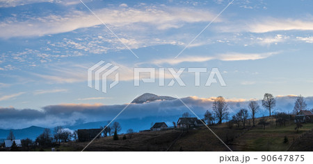 Picturesque pre sunrise morning above late autumn mountain countryside. Ukraine, Carpathian Mountains, Petros top in far. Peaceful traveling, seasonal, nature and countryside beauty concept scene. Picturesque pre sunrise morning above late autumn mountain countryside. Ukraine, Carpathian Mountains, Petros top in far. Peaceful traveling, seasonal, nature and countryside beauty concept scene. 90647875