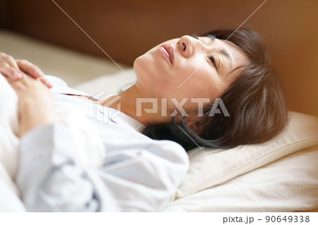 ベッドで横になる中年女性　 90649338