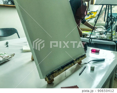 white and blank canvas. artist's workplace. space has been prepared for applying the image to the picture. canvas stand smeared in dark blue paint white and blank canvas. artist's workplace. space has been prepared for applying the image to the picture. canvas stand smeared in dark blue paint 90650412