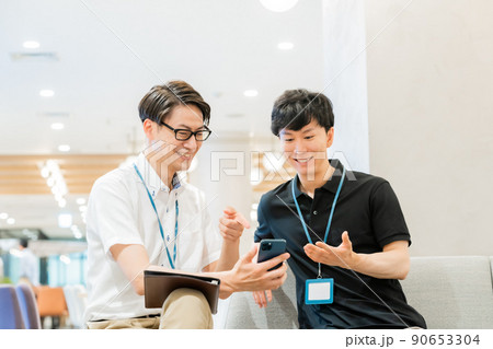スマホを2人で見るビジネスマン スマホを2人で見るビジネスマン 90653304